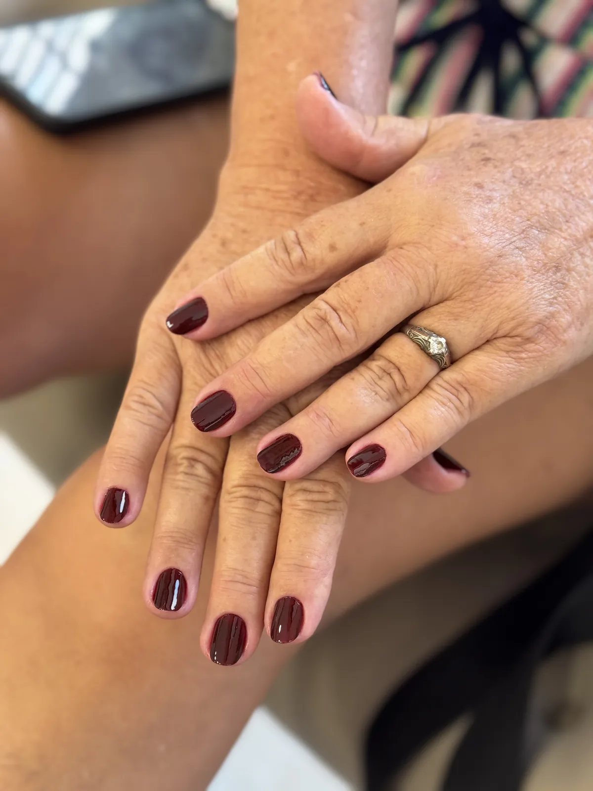 Mãos com esmaltação em tom de vinho
